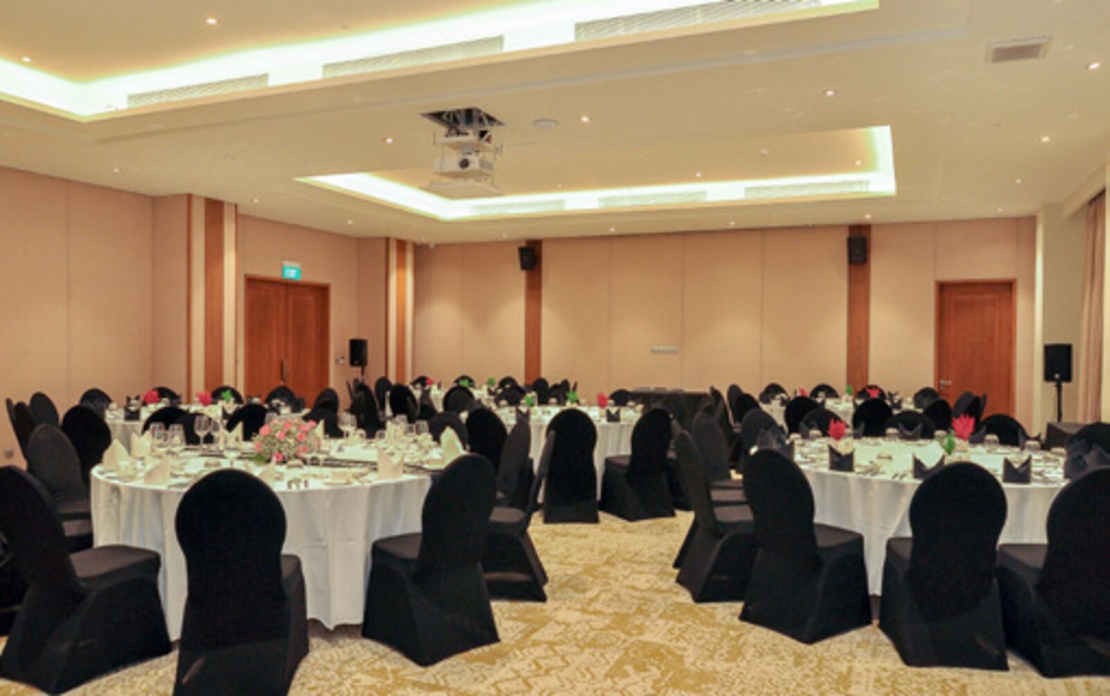 Banquet room set with round tables and black chair covers